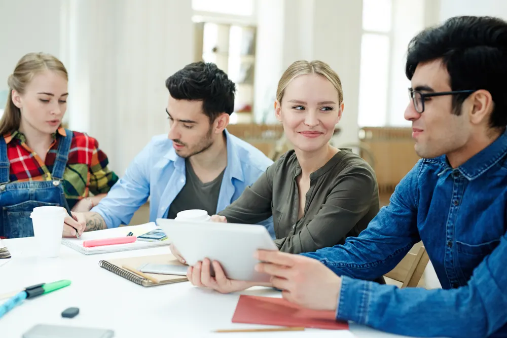 Students discussing their work at a table